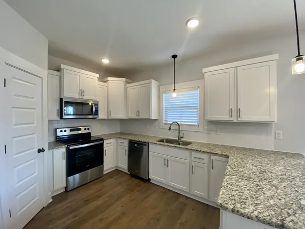 a kitchen with stainless steel appliances granite countertop a sink stove and refrigerator