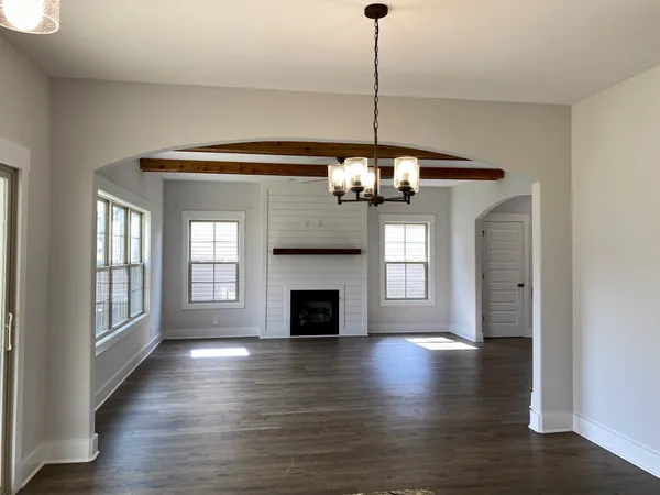 a view of a livingroom with a chandelier wooden floor and fireplace
