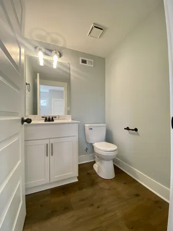 a bathroom with a toilet a sink and mirror