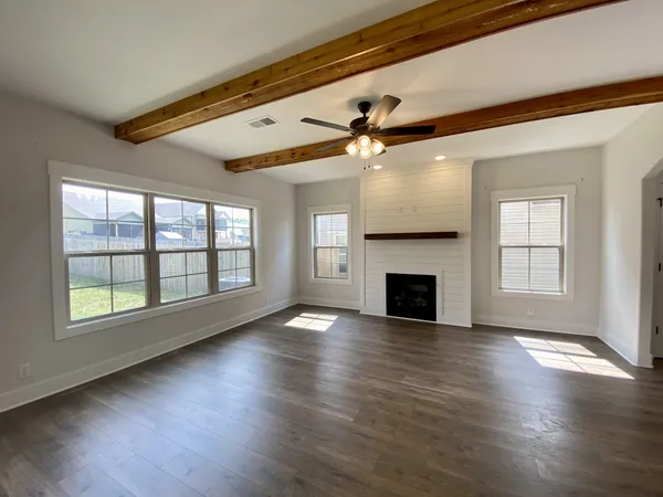 a view of empty room with wooden floor and fireplace