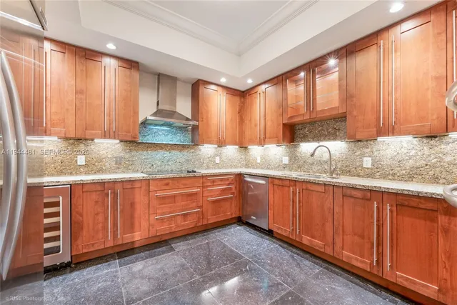 a kitchen with granite countertop wooden cabinets stainless steel appliances a sink and a window