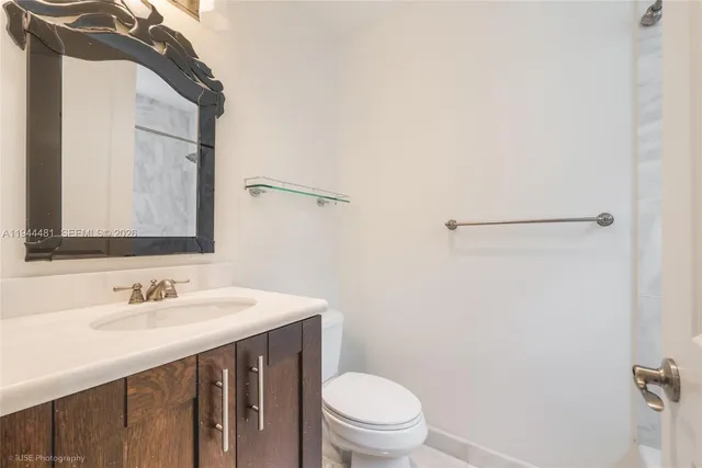 a bathroom with a sink vanity mirror and toilet