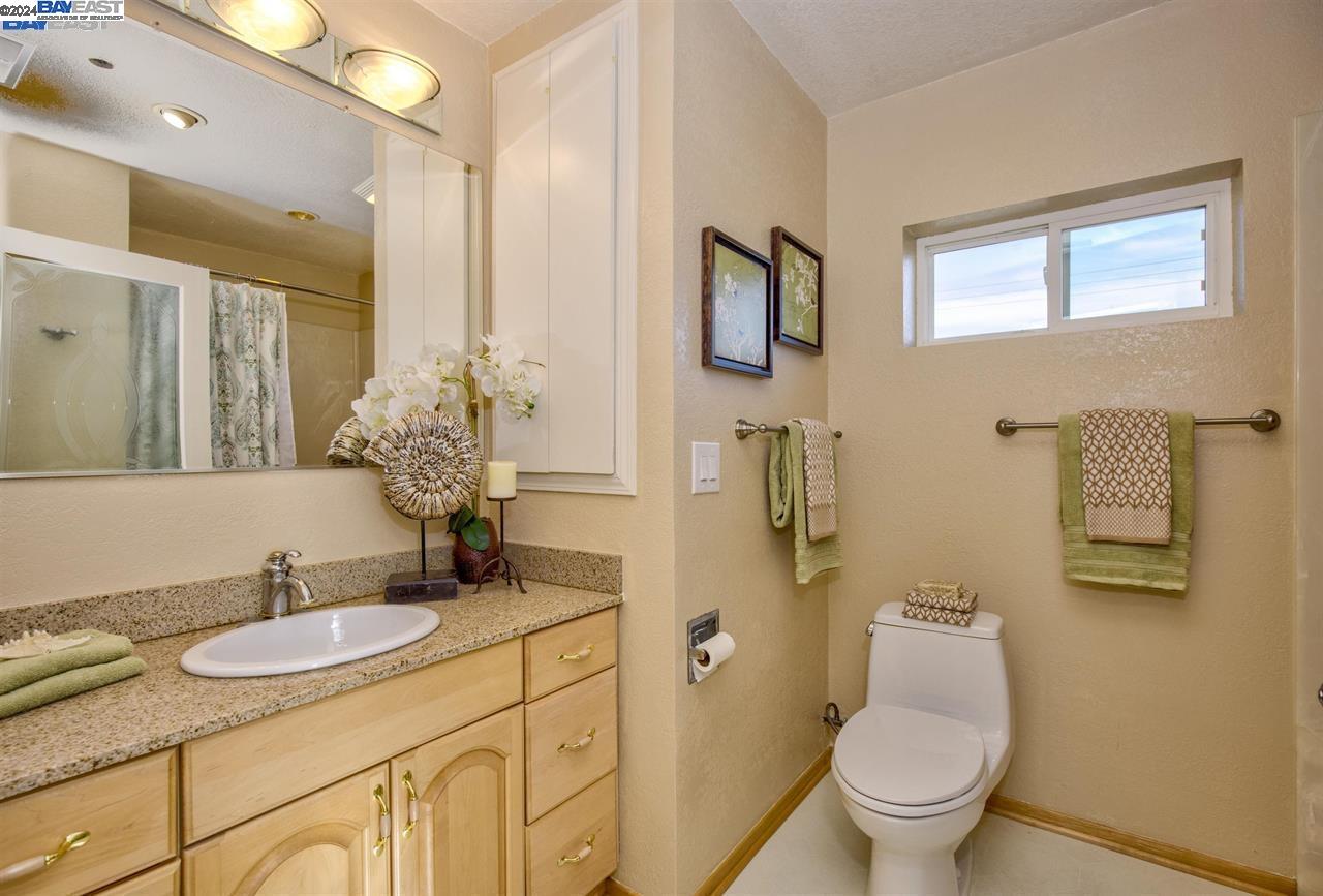 1746 3rd Street, Unit B Livermore, CA 94550 - Photo 11 of 12 a bathroom with a granite countertop sink toilet and mirror