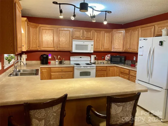 a kitchen with stainless steel appliances a stove a sink a microwave a refrigerator and cabinets