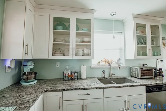 a kitchen with granite countertop a sink and cabinets