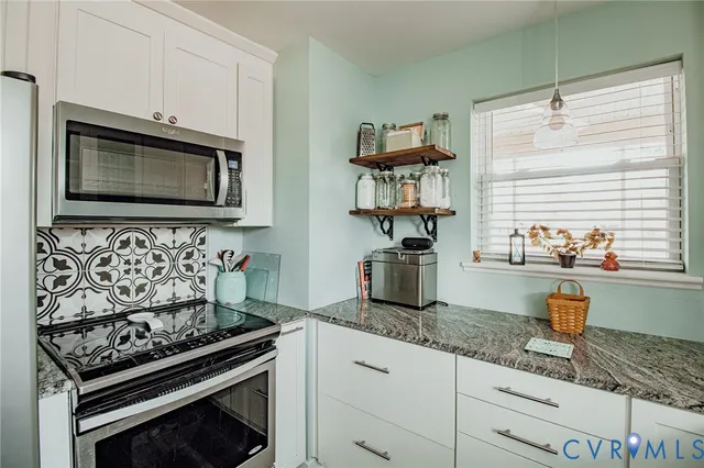a kitchen with granite countertop stainless steel appliances and cabinets