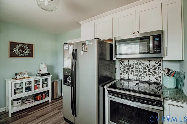 a kitchen with stainless steel appliances granite countertop a stove a refrigerator and cabinets
