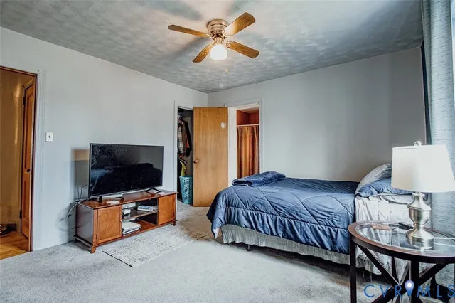 a bedroom with a bed and a flat tv screen on dresser