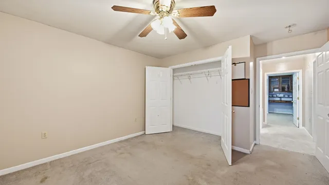 an empty room with chandelier fan