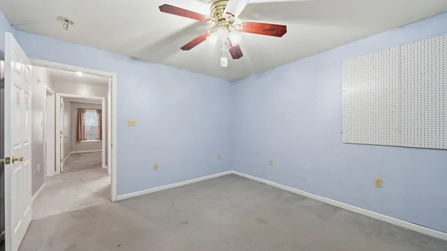 an empty room with closet and fan