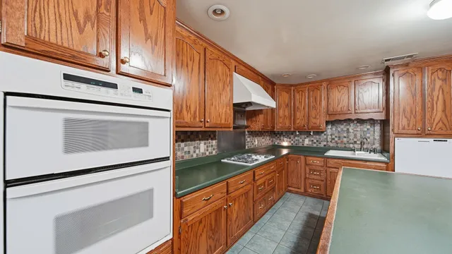 a kitchen with stainless steel appliances granite countertop a sink stove and microwave