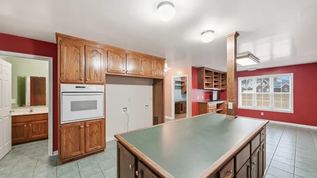 a kitchen with stainless steel appliances kitchen island granite countertop a refrigerator a stove and a sink with cabinets