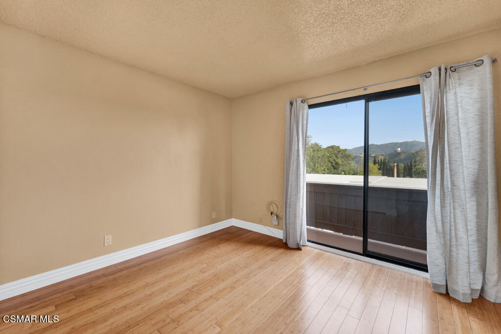 10240 Silverton Avenue, Unit 9 Tujunga, CA 91042 - Photo 16 of 23 an empty room with wooden floor and sliding door