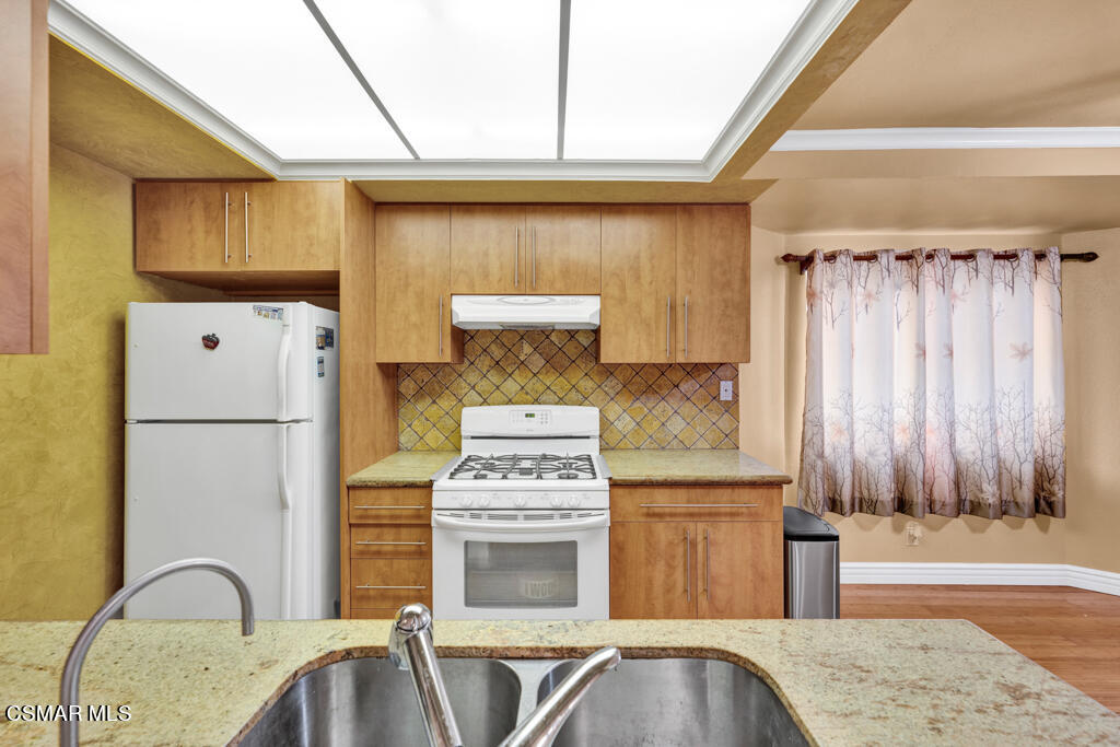 10240 Silverton Avenue, Unit 9 Tujunga, CA 91042 - Photo 6 of 23 a kitchen with stainless steel appliances granite countertop a refrigerator a sink and a stove