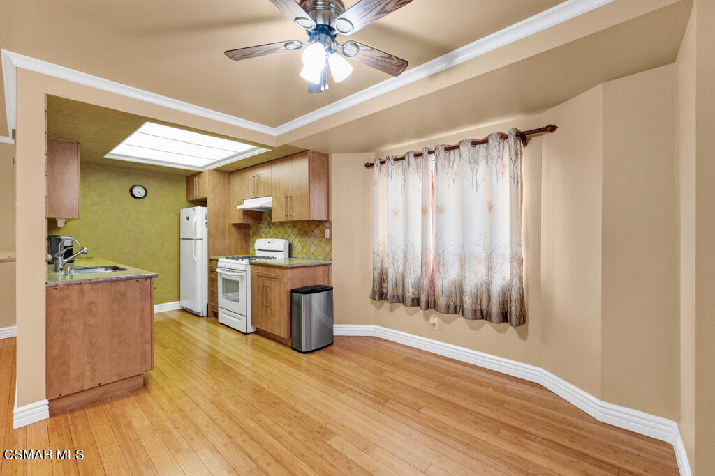 10240 Silverton Avenue, Unit 9 Tujunga, CA 91042 - Photo 9 of 23 a large white kitchen with a large window a sink and stainless steel appliances
