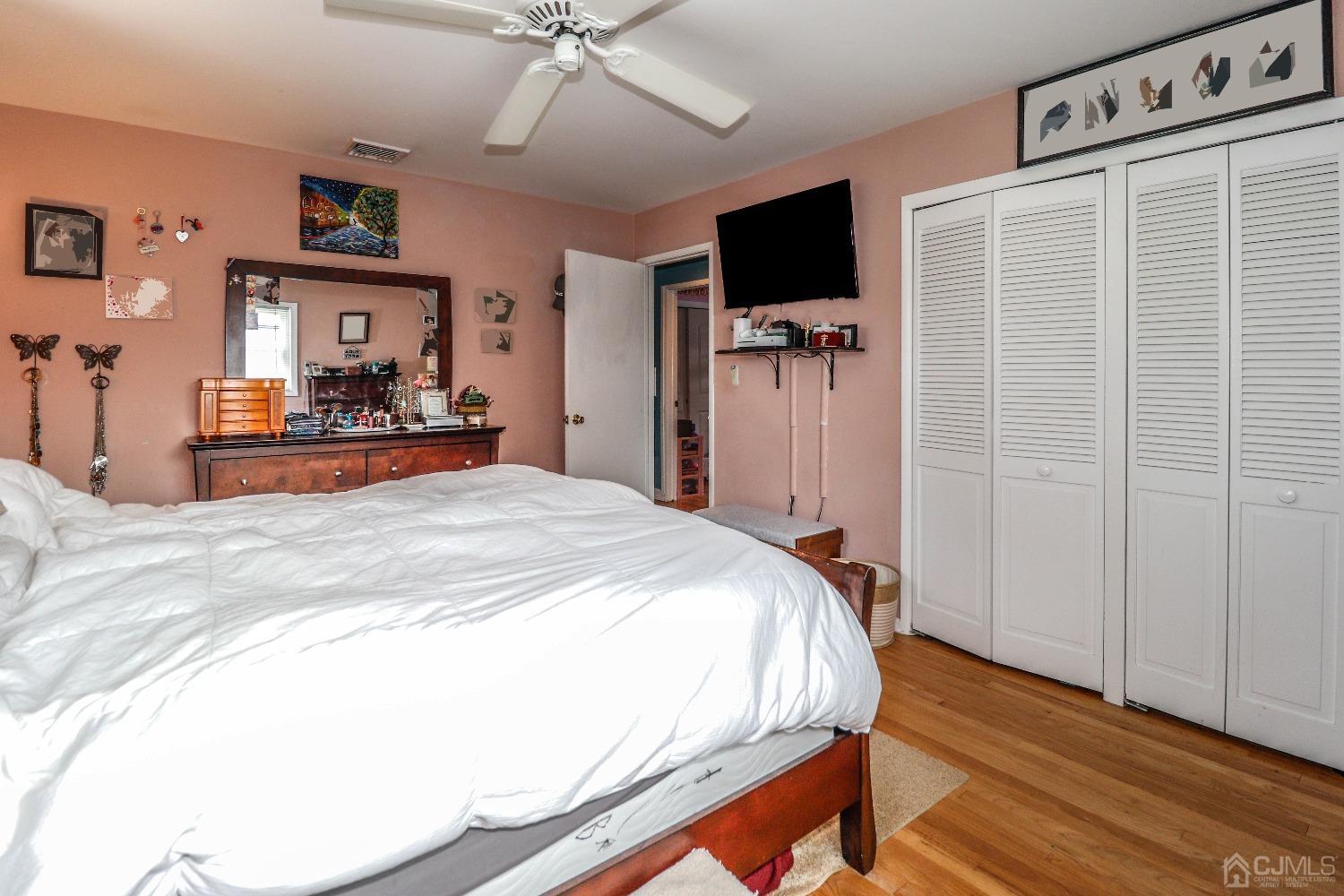 24 Finley Road Edison, NJ 08817 - Photo 18 of 27 a bedroom with a bed and a flat tv screen on wall