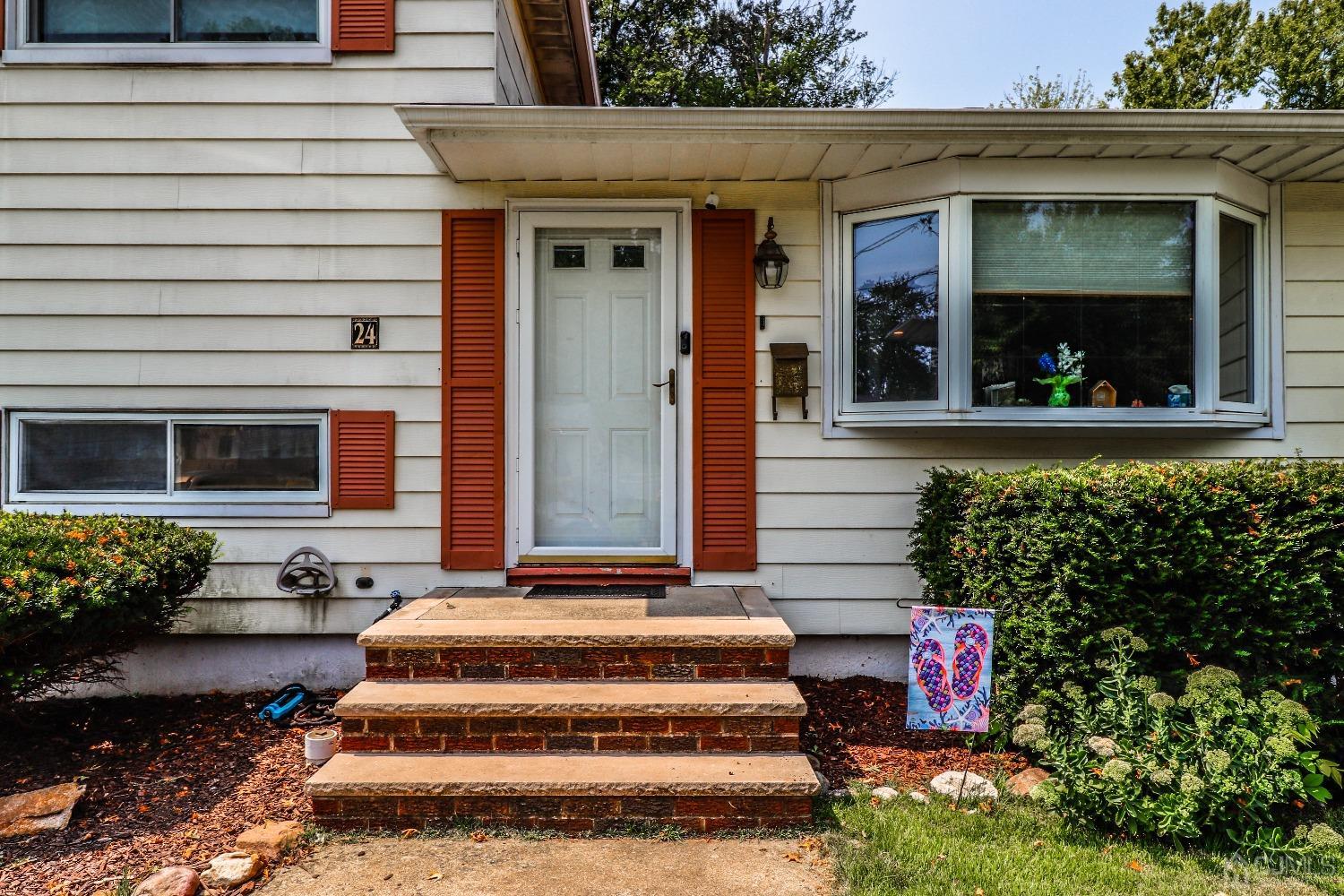 24 Finley Road Edison, NJ 08817 - Photo 4 of 27 a view of a house with potted plants and a bench
