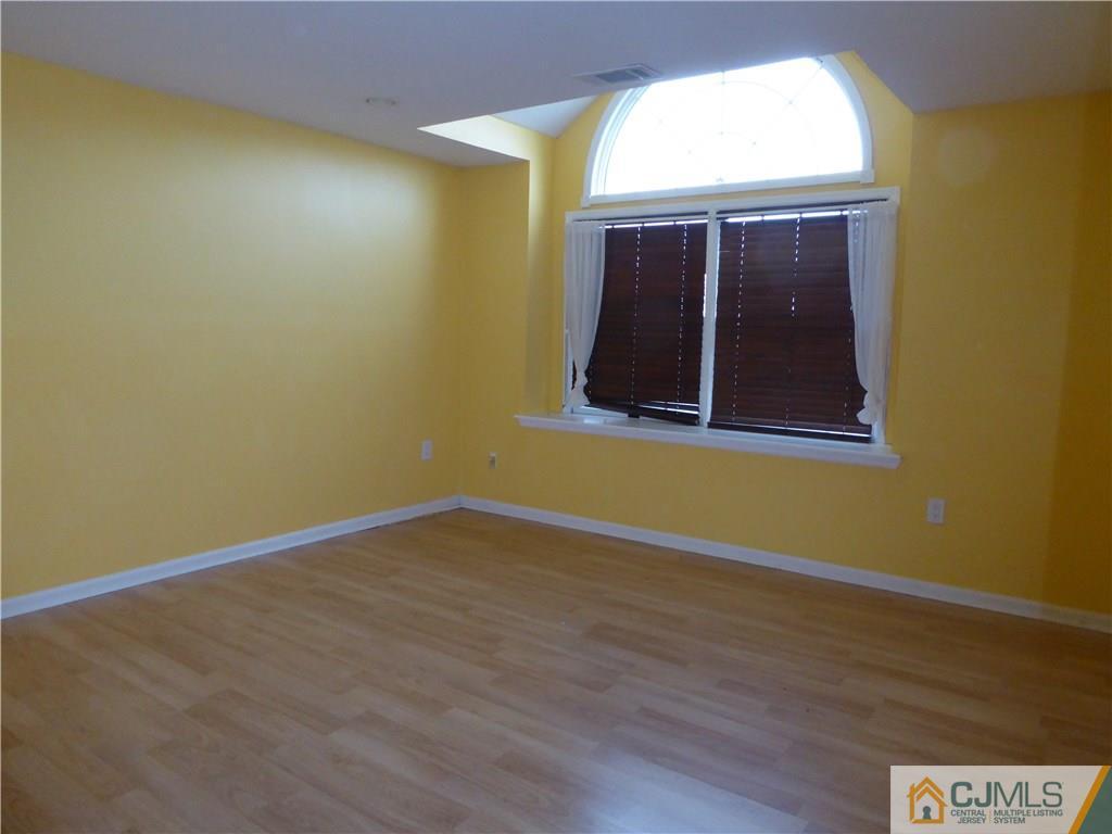 334 Edpas Road, Unit 334 New Brunswick, NJ 08901 - Photo 12 of 19 an empty room with wooden floor and windows