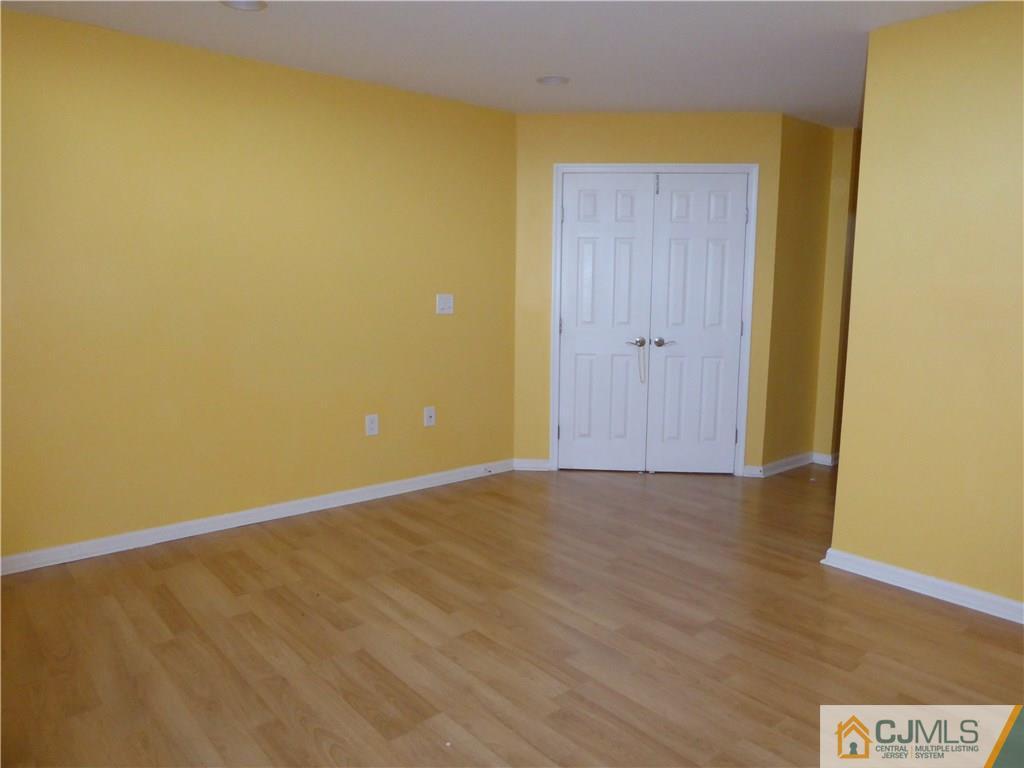 334 Edpas Road, Unit 334 New Brunswick, NJ 08901 - Photo 13 of 19 a view of an empty room with wooden floor and a window