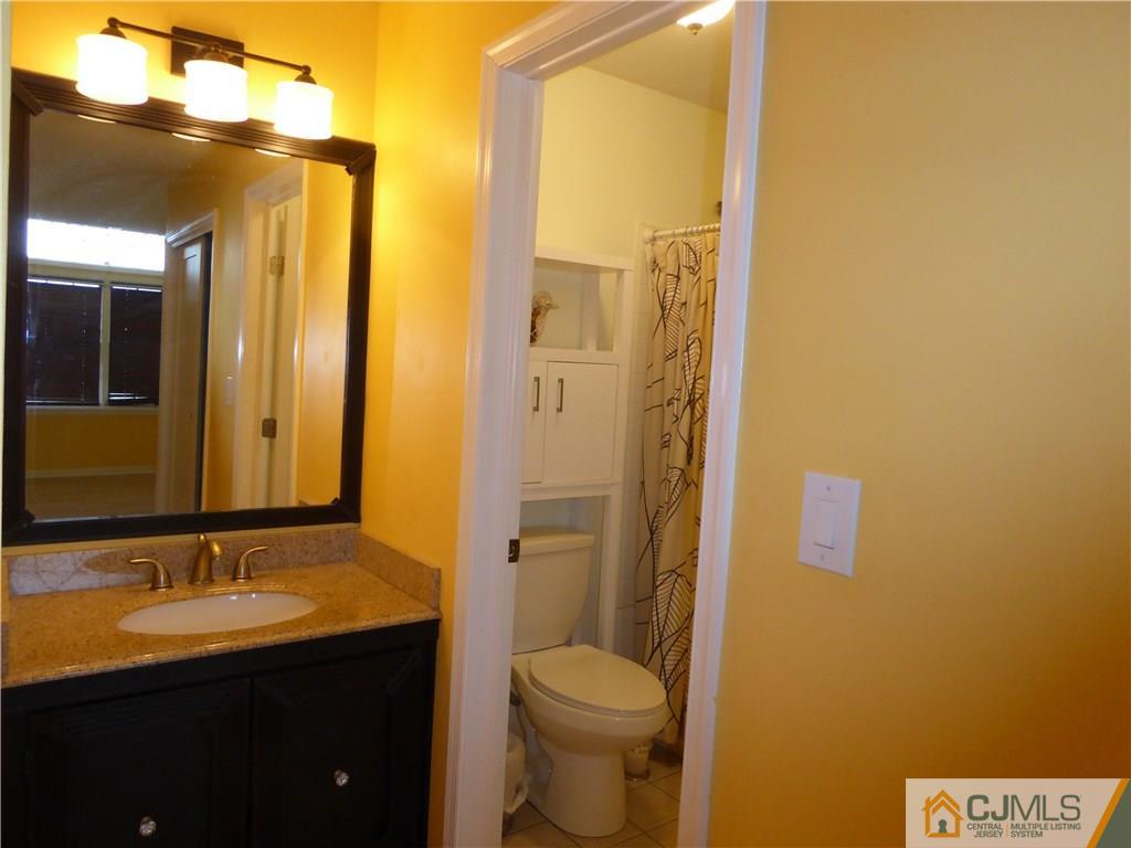 334 Edpas Road, Unit 334 New Brunswick, NJ 08901 - Photo 16 of 19 a bathroom with a granite countertop sink toilet and shower