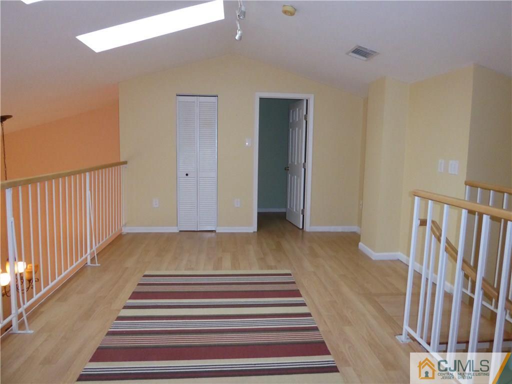 334 Edpas Road, Unit 334 New Brunswick, NJ 08901 - Photo 17 of 19 a view of a hallway with wooden floor and stairs
