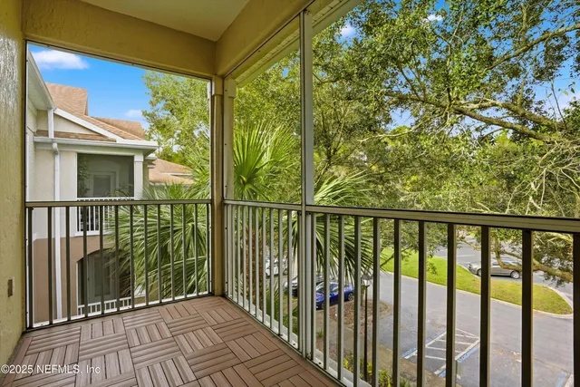a view of a balcony with floor to ceiling windows and wooden fence