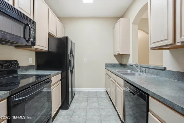 a kitchen with granite countertop white cabinets and a sink
