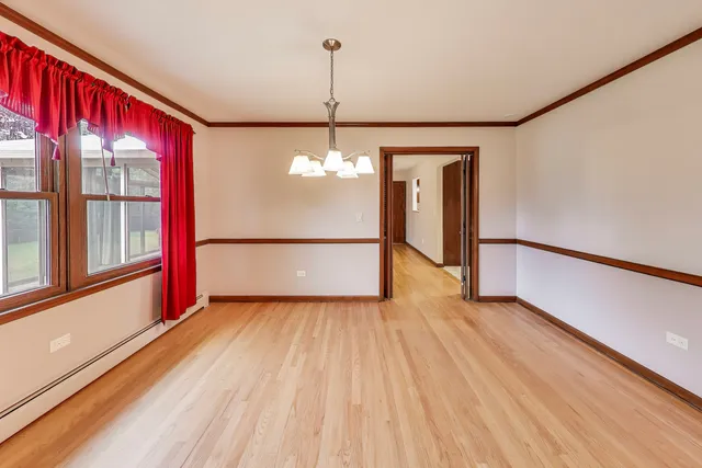 a view of a room with wooden floor and a window