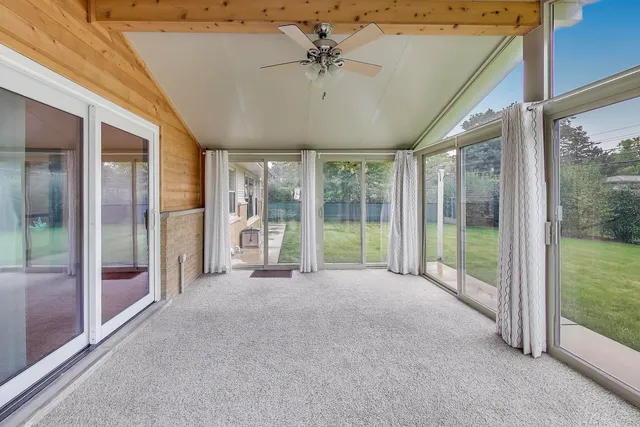 a view of a room with window a ceiling fan and front door