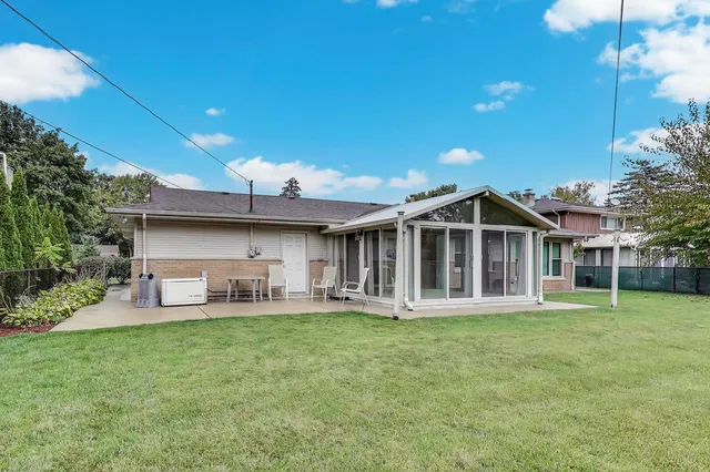 a front view of a house with a garden and trees