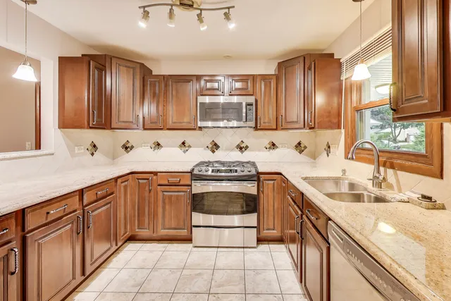 a kitchen with stainless steel appliances granite countertop a sink stove and cabinets