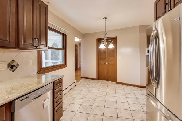 a kitchen with stainless steel appliances granite countertop a refrigerator a stove and a sink with granite countertops