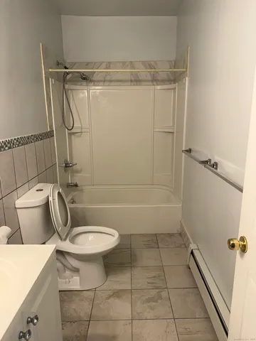 a bathroom with a granite countertop toilet and a shower