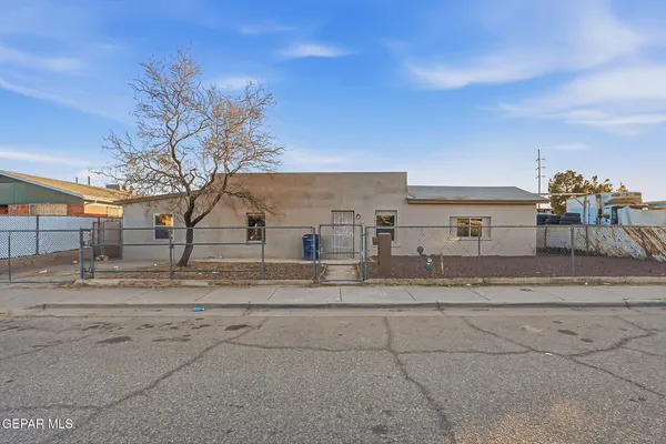 a view of a dirt road and a building in the background