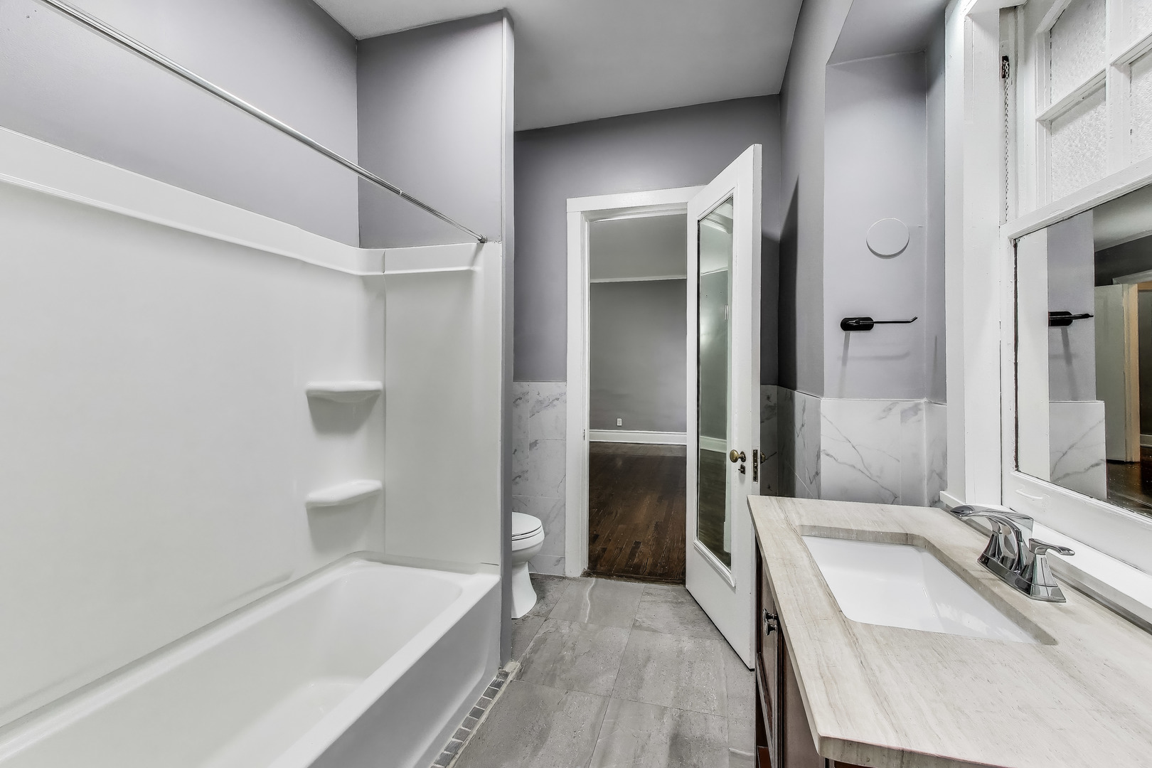 1615 East Hyde Park Boulevard, Unit 2 Chicago, IL 60615 - Photo 11 of 19 a bathroom with a tub sink and a mirror