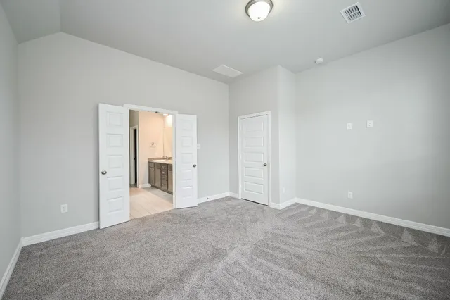 an empty room with an entryway and wooden floor