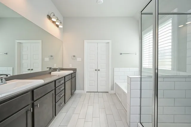 a spacious bathroom with a granite countertop sink a toilet a mirror and shower