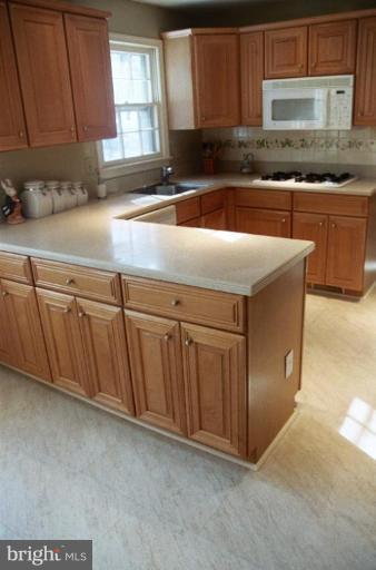7644 Chancellor Way Springfield, VA 22153 - Photo 6 of 29 a kitchen with stainless steel appliances granite countertop a sink a stove a microwave a counter space and cabinets