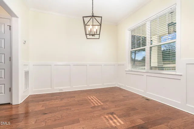 an empty room with wooden floor and white walls