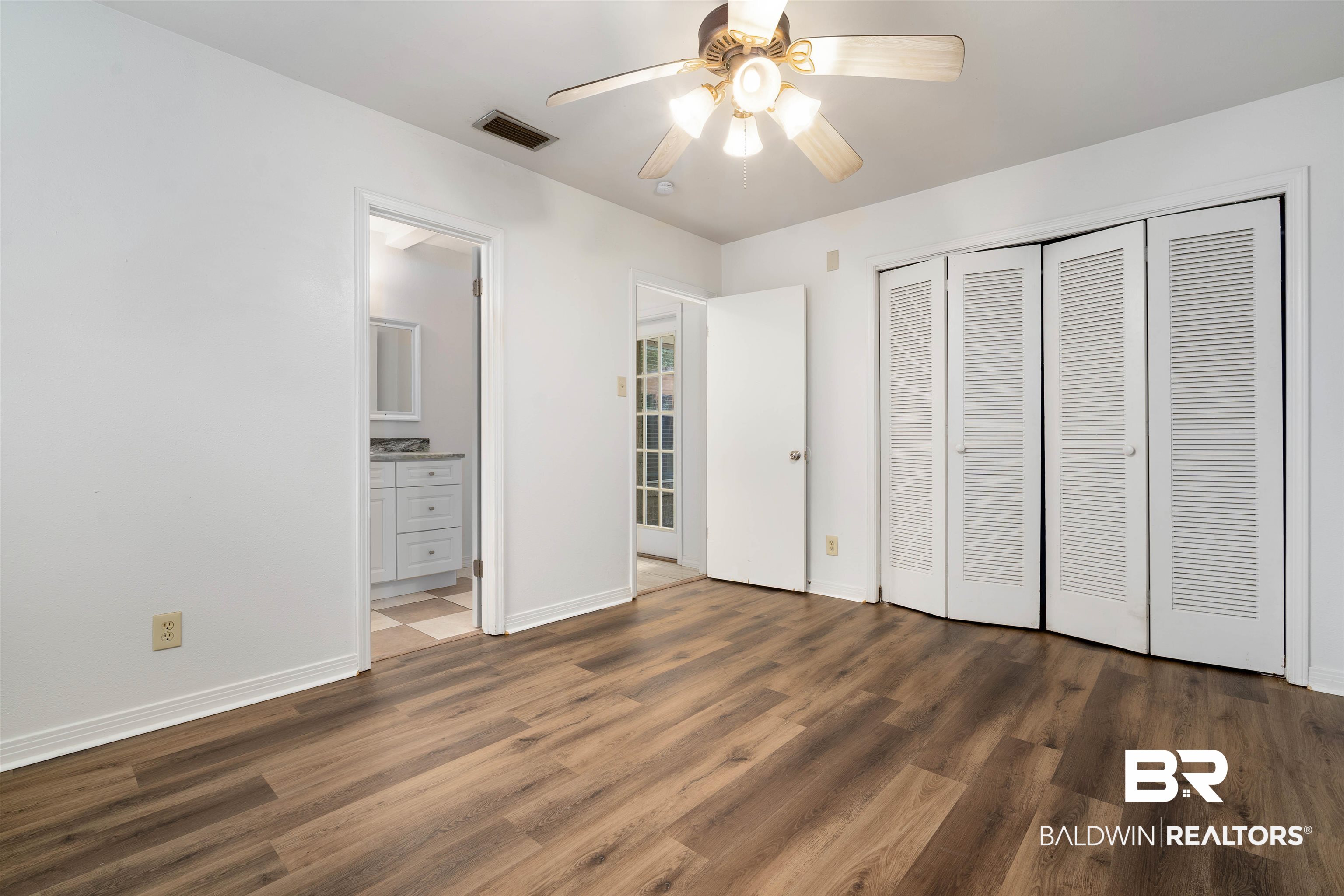 570 Markham Drive Mobile, AL 36609 - Photo 15 of 25 Unfurnished bedroom featuring ensuite bathroom, wood finished floors, a closet, baseboards, and visible vents