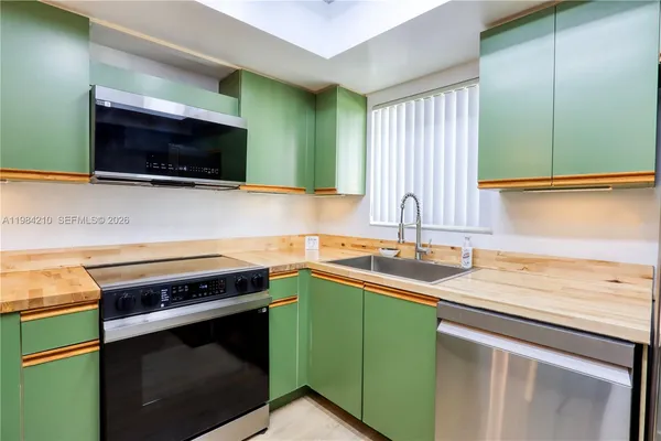 a view of a kitchen with a sink and a washer dryer