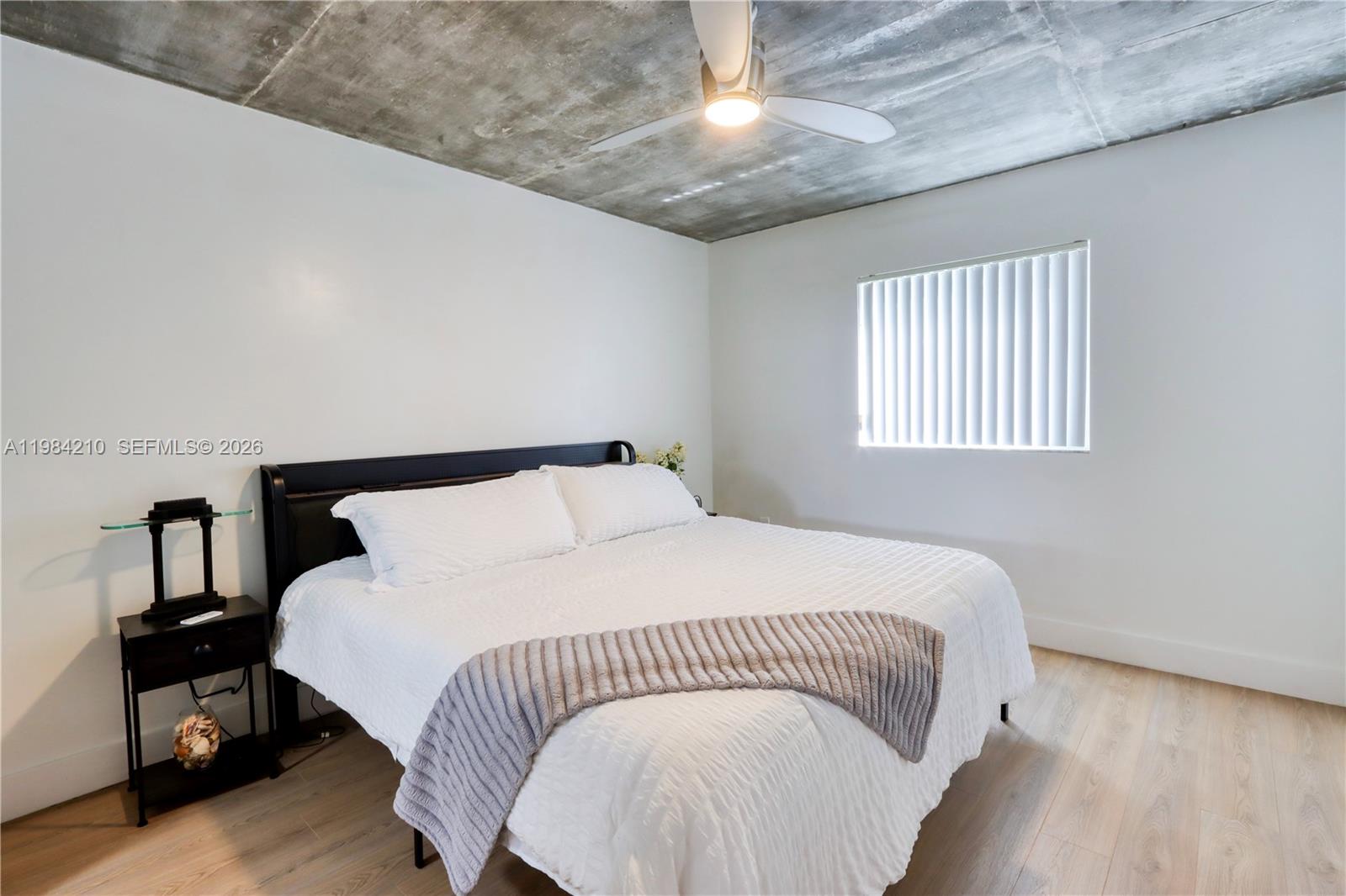 201 Northwest 7th Street, Unit 307 Miami, FL 33136 - Photo 14 of 22 a bed sitting in a bedroom next to a window
