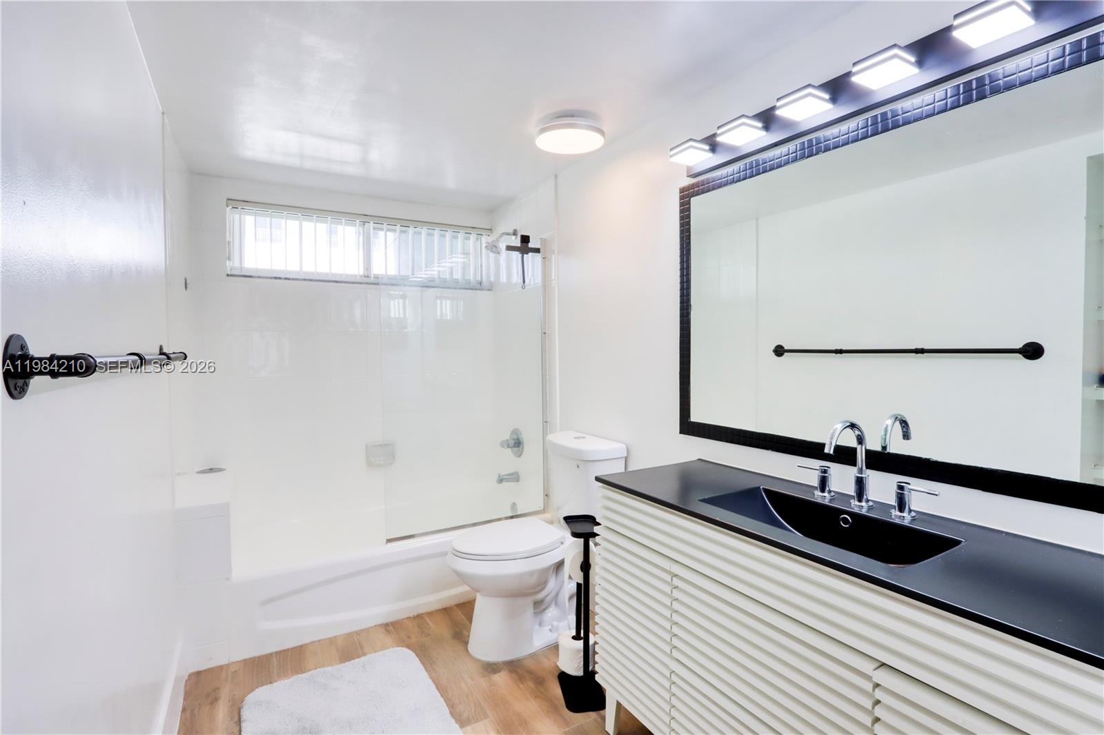201 Northwest 7th Street, Unit 307 Miami, FL 33136 - Photo 16 of 22 a bathroom with a sink a toilet a mirror and shower
