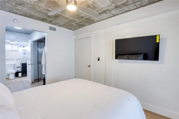 a bedroom with a bed and a flat screen tv