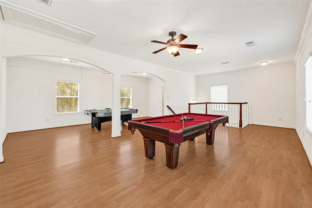 a room with pool table and wooden floor