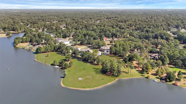 an aerial view of a house with a yard and lake view