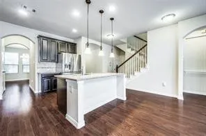 a view of entryway and kitchen with wooden floor
