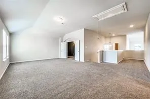 a view of an empty room with wooden floor fireplace and a window