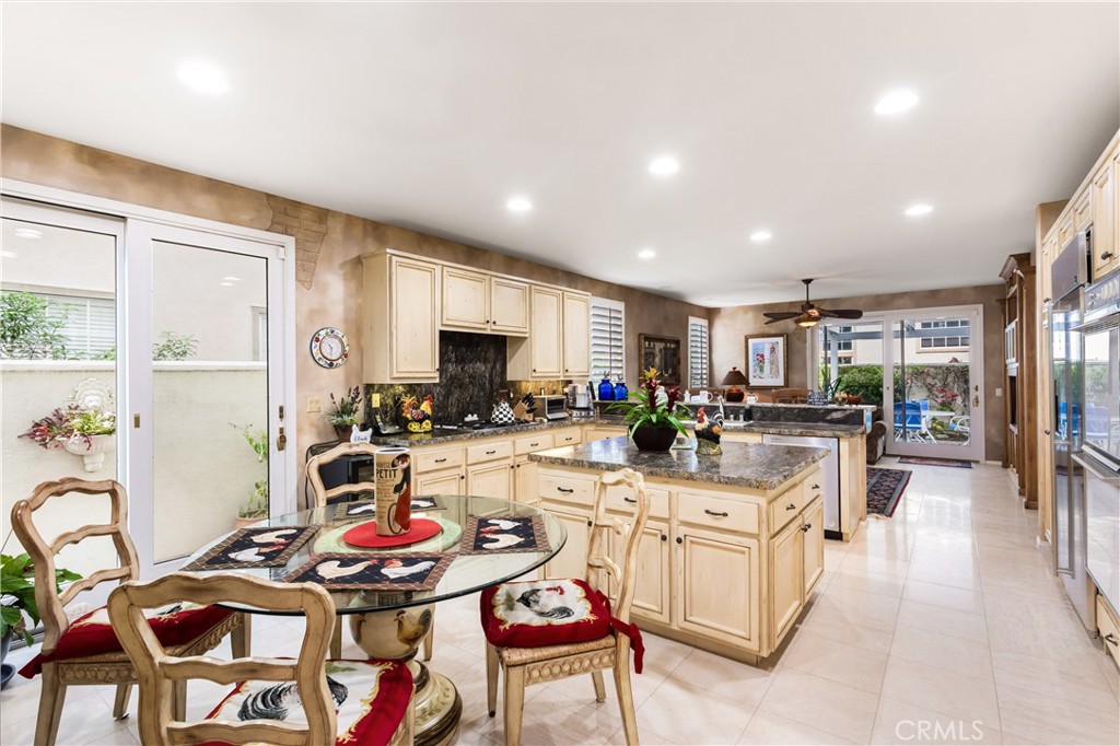 12665 Stanton Avenue Tustin, CA 92782 - Photo 14 of 52 a kitchen with stainless steel appliances kitchen island granite countertop a stove a sink a dining table and chairs with wooden floor