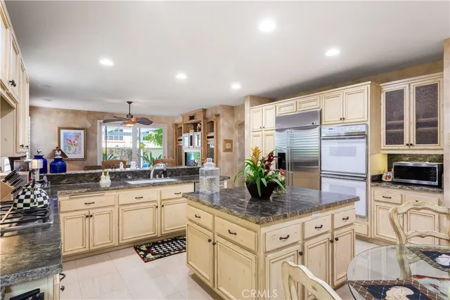 a kitchen with granite countertop a sink stainless steel appliances and white cabinets